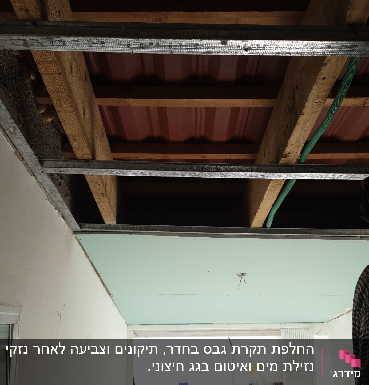 תקרת עץ עם קורות מתכת בתהליך שיפוץ